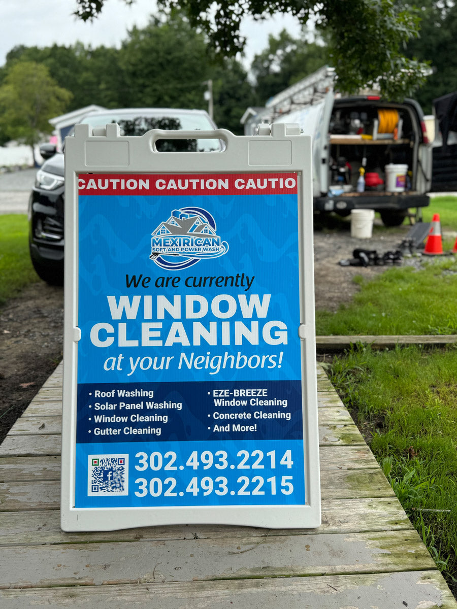 Mexirican Soft and Power Wash A-frame sign reading “Window Cleaning at Your Neighbors,” set up outdoors at residential jobsite, printed by WCR Marketing.