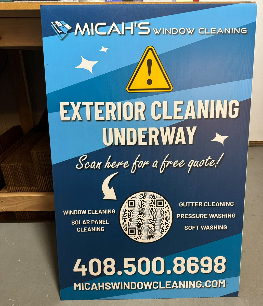 Micah’s Window Cleaning A-frame sign reading “Exterior Cleaning Underway” with service list and large QR code for free quote, printed by WCR Marketing.