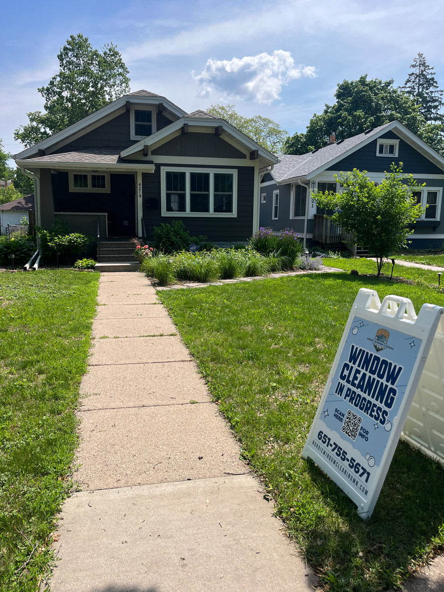 Nordic Window Cleaning A-frame sign reading “Window Cleaning In Progress” displayed on residential lawn near front walkway, printed by WCR Marketing.