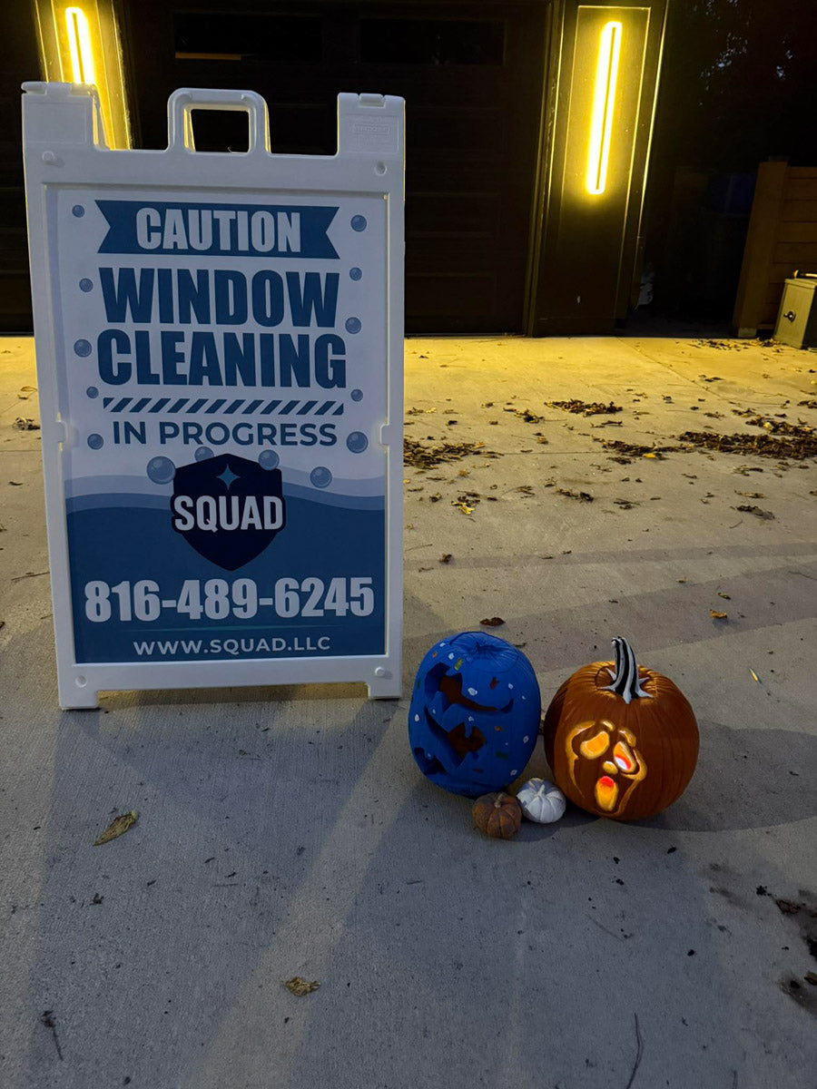Squad Window Cleaning A-frame sign with Halloween pumpkins on driveway, printed by WCR Marketing.