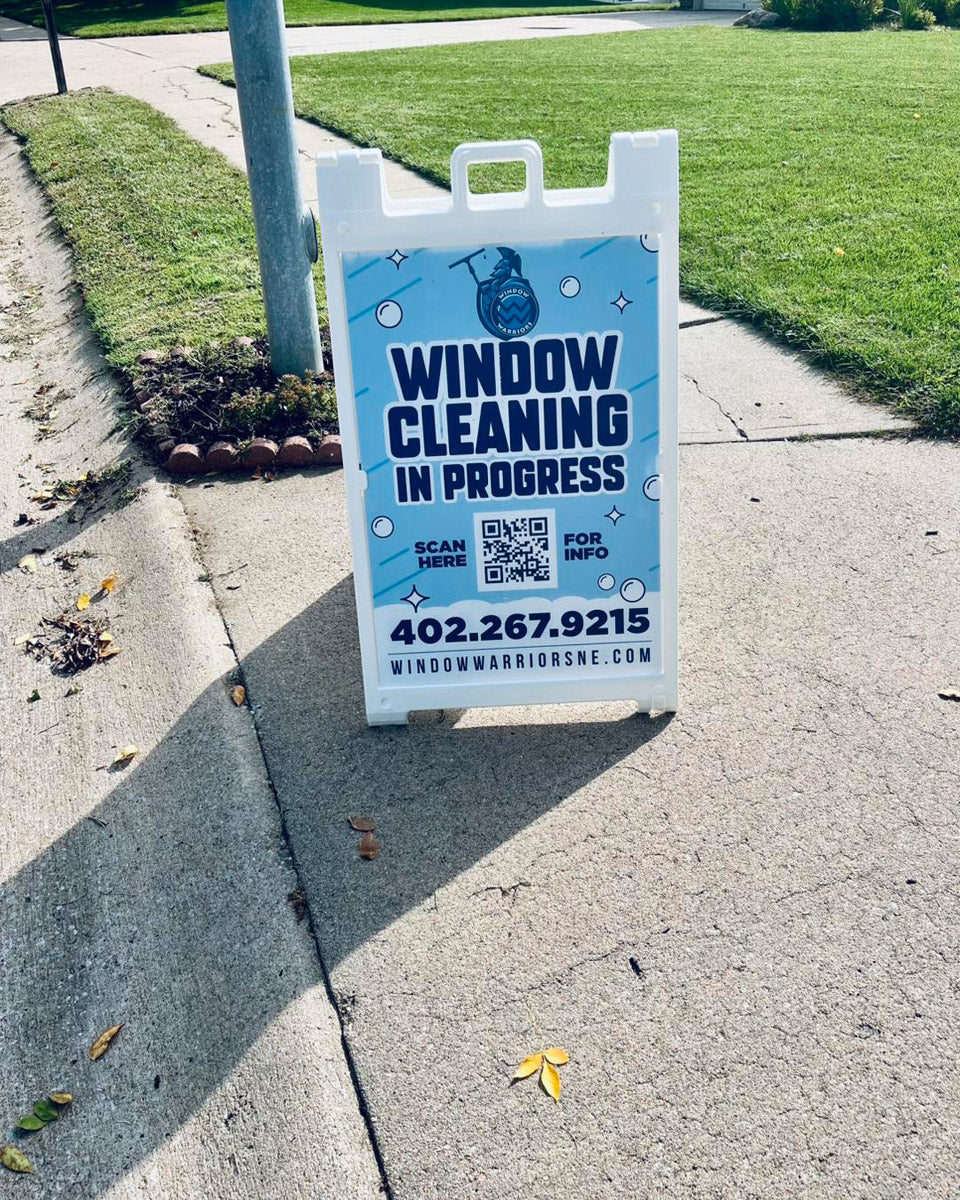 Window Warriors NE A-frame sign placed on residential sidewalk reading “Window Cleaning In Progress,” printed by WCR Marketing.