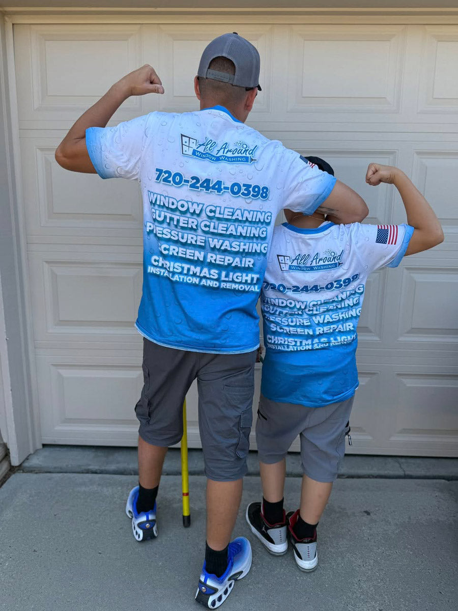 Father and son showing back of All Around Window Washing blue dye-sub jerseys printed with service list and company branding, printed by WCR Marketing.