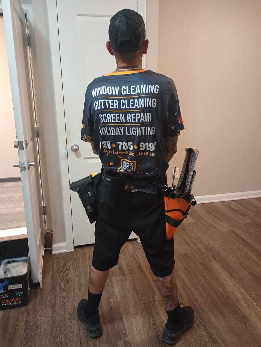 Back view of Damian The Window Cleaner jersey listing services—window cleaning, gutter cleaning, screen repair, holiday lighting—with phone and website, printed by WCR Marketing.