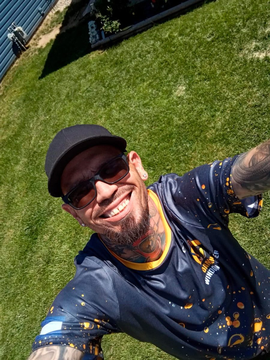 Damian The Window Cleaner dye-sublimated shirt with orange trim and bubble graphic design on dark navy background, printed by WCR Marketing.