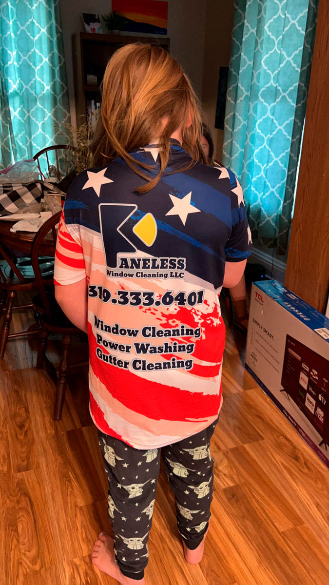 Youth wearing a patriotic red-white-and-blue Kaneless Window Cleaning dye-sub jersey with services and phone number printed on the back, printed by WCR Marketing.