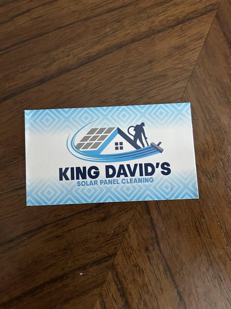 King David's Solar Panel Cleaning business card featuring the logo of a house with solar panels on a wood floor, printed by WCR Marketing.