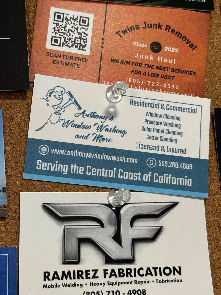 Anthony’s Window Washing and More business card pinned to bulletin board alongside other local business cards, showing cartoon cleaner logo, printed by WCR Marketing.