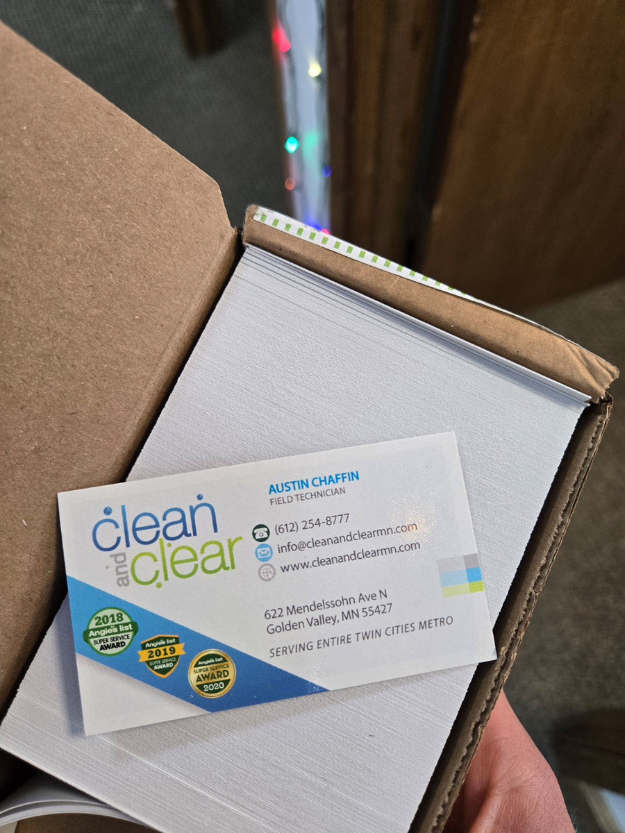 Clean and Clear business card for field technician Austin Chaffin displayed in box, featuring contact info and award badges, printed by WCR Marketing.