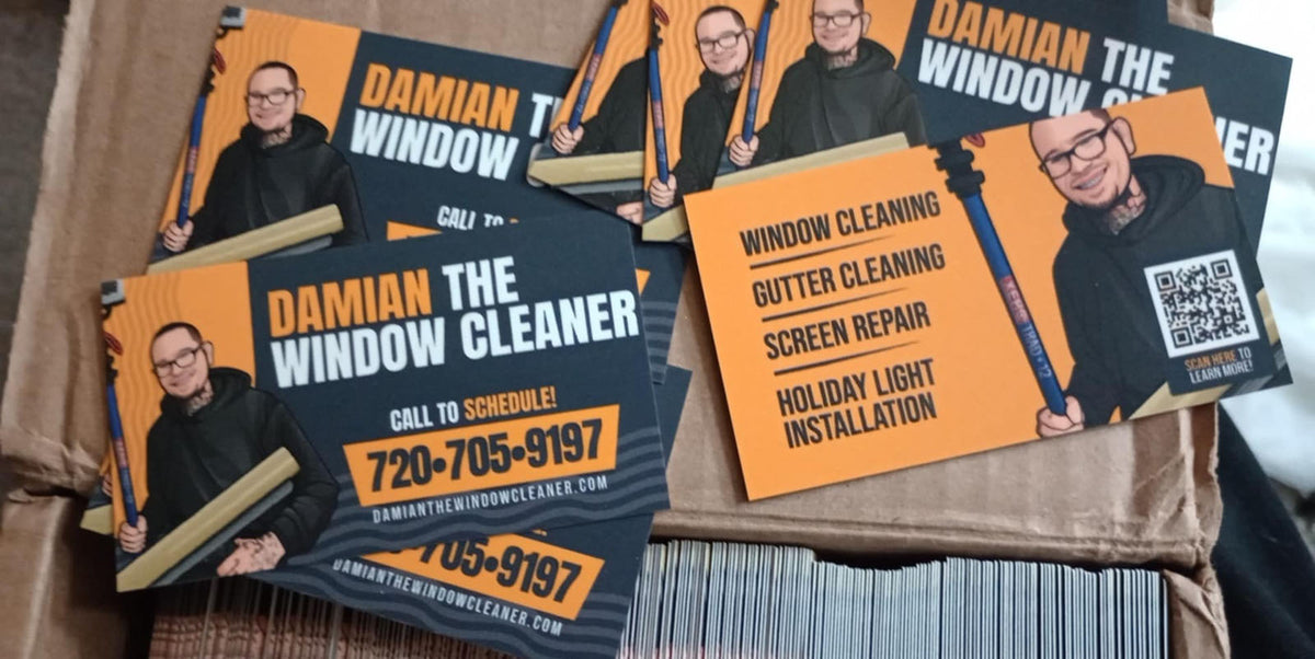 Damian The Window Cleaner business cards inside packaging box, showing bold yellow and black brand design with illustration, printed by WCR Marketing.