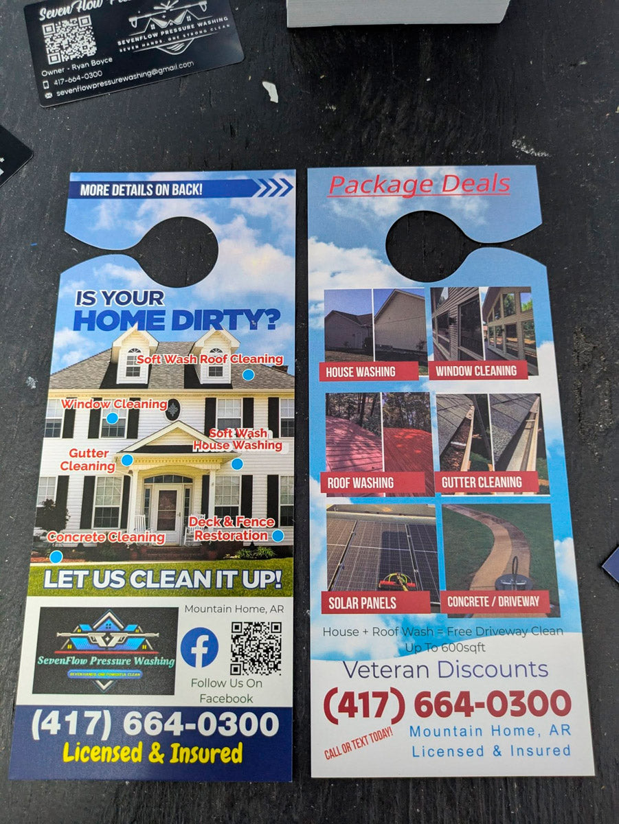 Seven Flow Pressure Washing door hangers displayed on table showing package deals for house washing, window cleaning, roof washing, and gutter cleaning, printed by WCR Marketing.