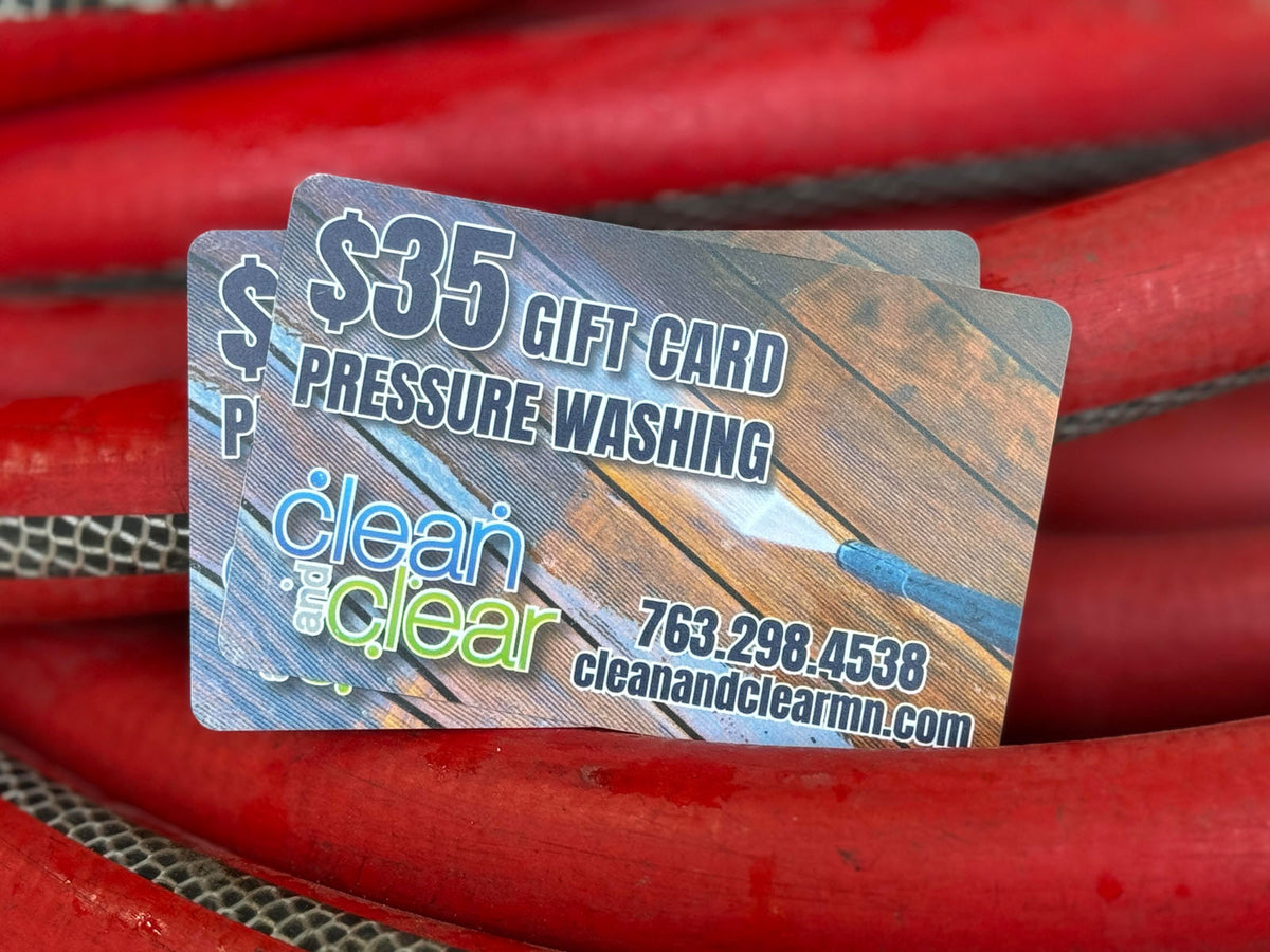 Close-up of Clean and Clear Pressure Washing $35 gift cards placed on red hose, featuring logo and contact information, printed by WCR Marketing.