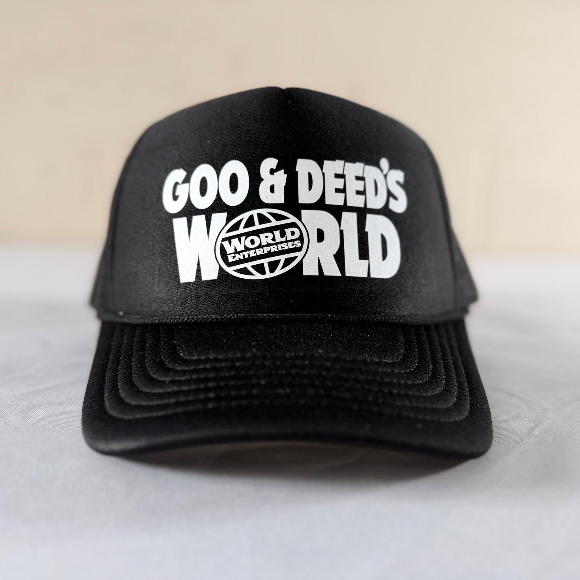Front view of black Goo and Deeds World Enterprises foam trucker mesh hat