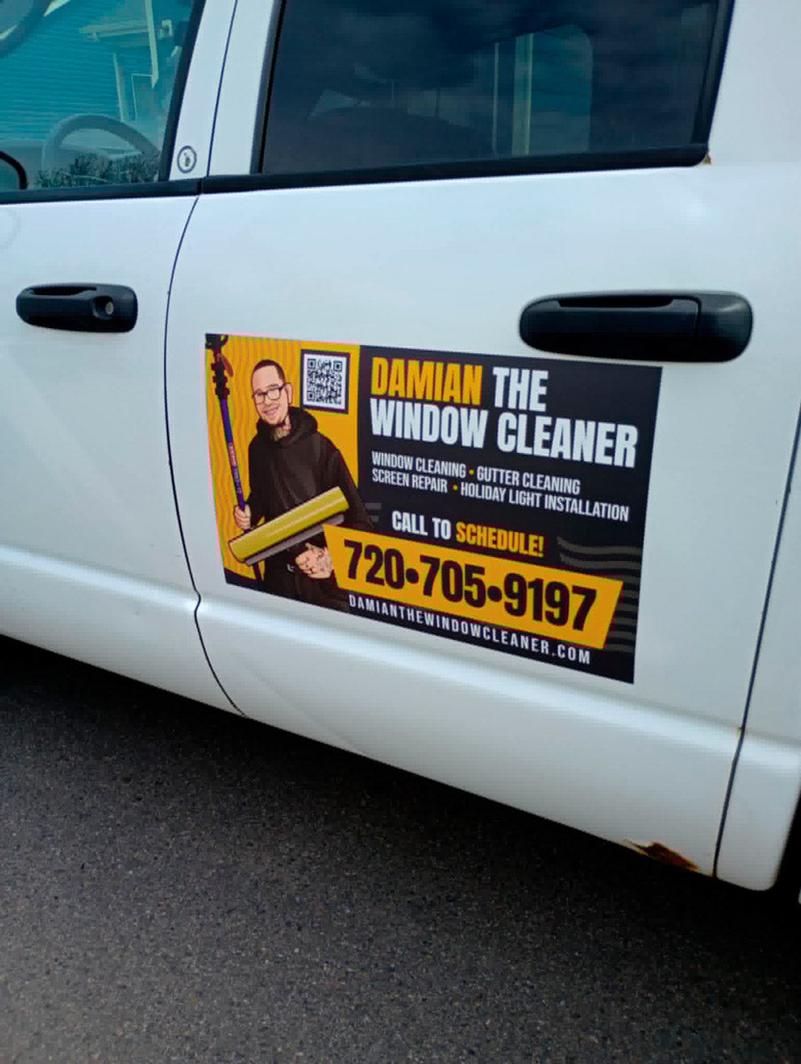 Close-up of a Damian The Window Cleaner service magnet on a white truck door, printed by WCR Marketing.