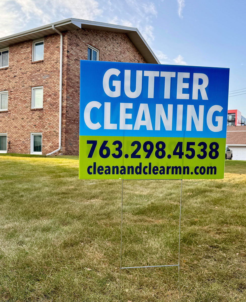 Gutter cleaning yard sign for Clean and Clear MN displayed on residential lawn with blue and green gradient design, printed by WCR Marketing.
