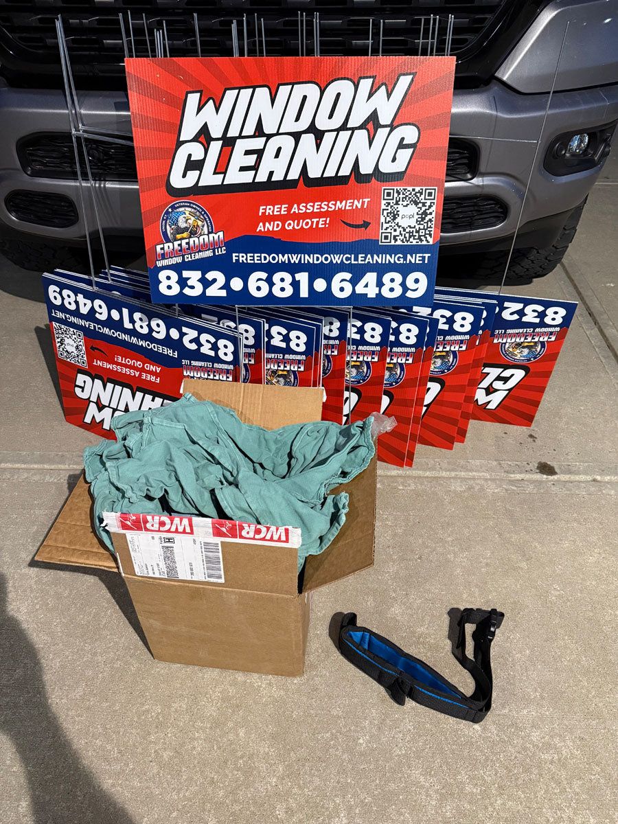 Stack of Freedom Window Cleaning yard signs featuring bold red, white, and blue design with QR code and free assessment offer, printed by WCR Marketing.