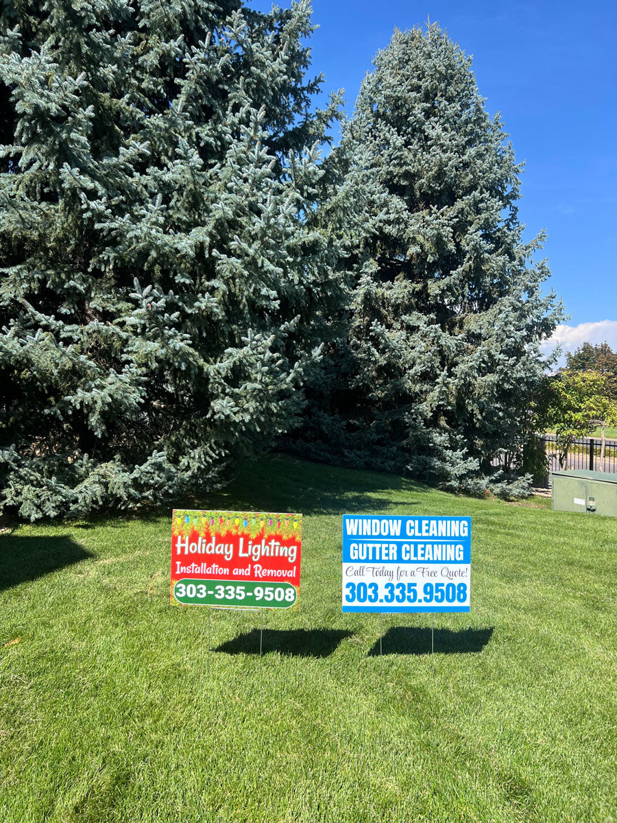 Holiday Lighting Installation yard sign paired with a Window and Gutter Cleaning yard sign displayed together on a lawn, printed by WCR Marketing.