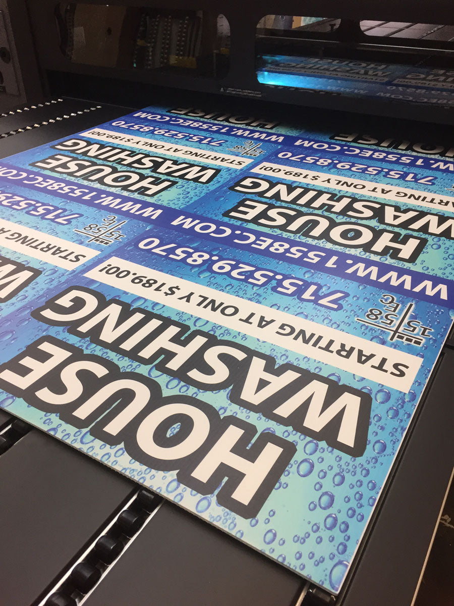 House washing yard signs with blue bubble background being printed on a flatbed production printer, produced by WCR Marketing.