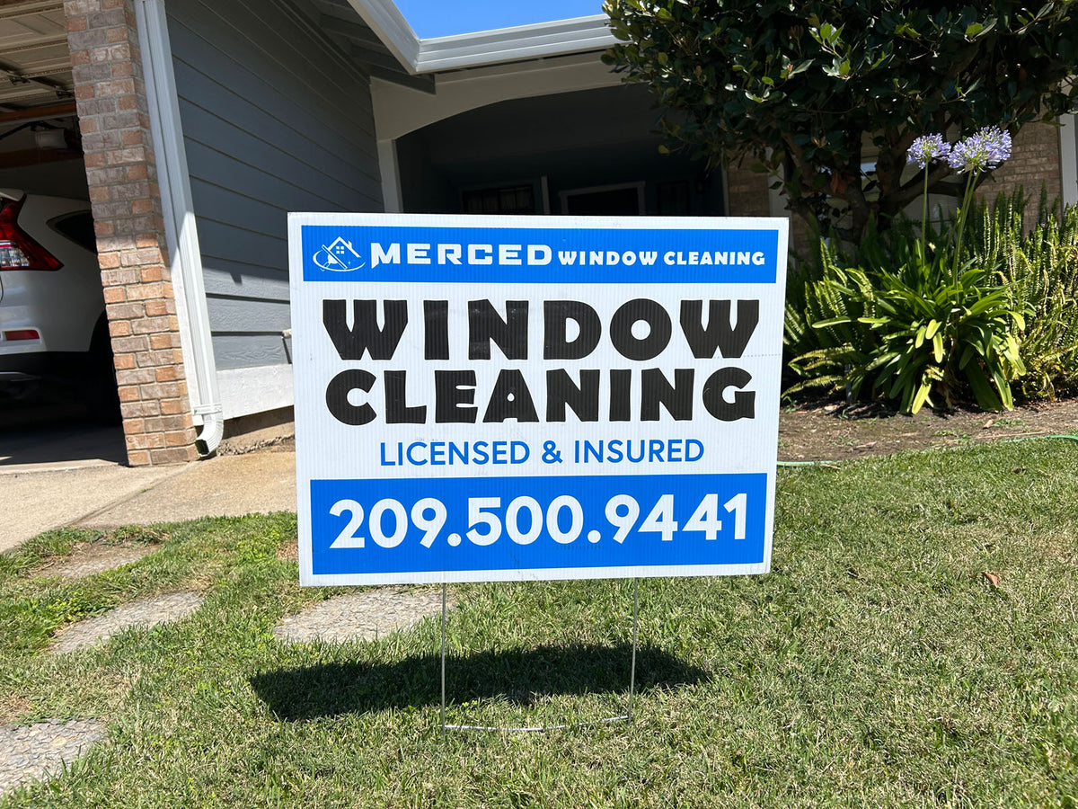 Close-up photo of a Merced Window Cleaning yard sign featuring blue and white design with licensed and insured message, printed by WCR Marketing.