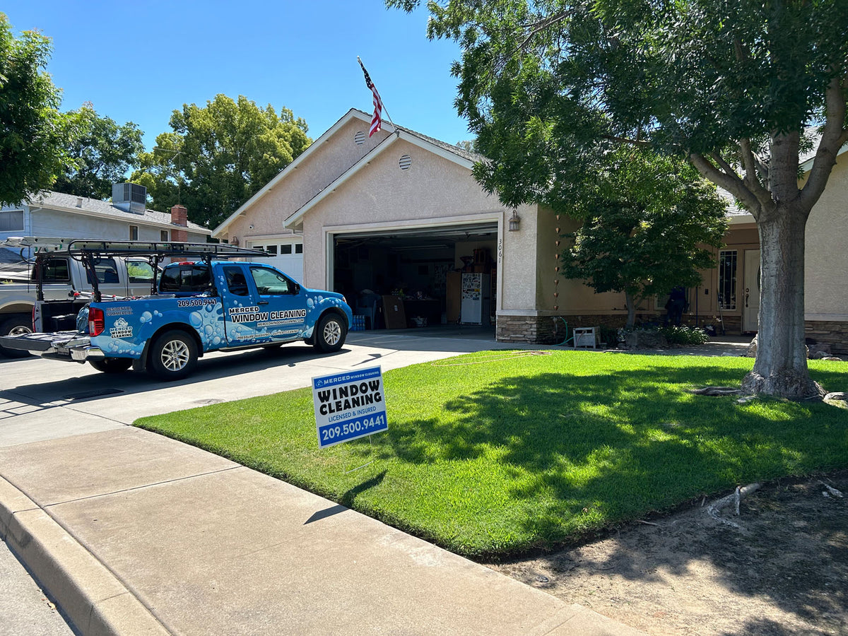 Merced Window Cleaning yard sign displayed on a residential lawn with branded company truck parked in driveway, printed by WCR Marketing.