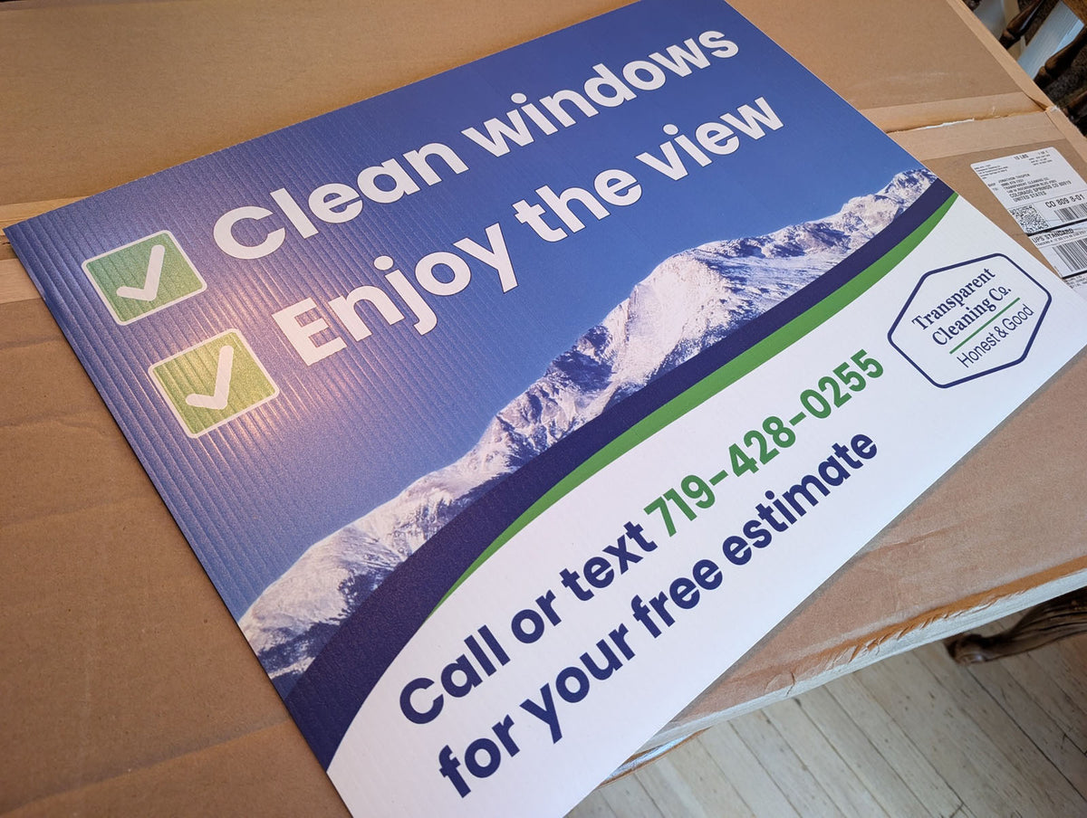 Clean windows yard sign for Transparent Cleaning Co. featuring mountain background, checkmark graphics, and phone number, printed by WCR Marketing.