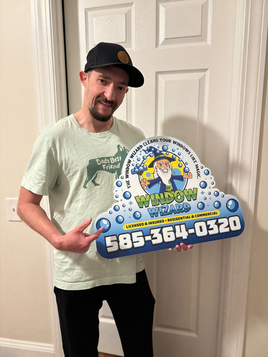 Custom die-cut Window Wizard yard sign featuring mascot illustration held by customer inside home, printed by WCR Marketing.